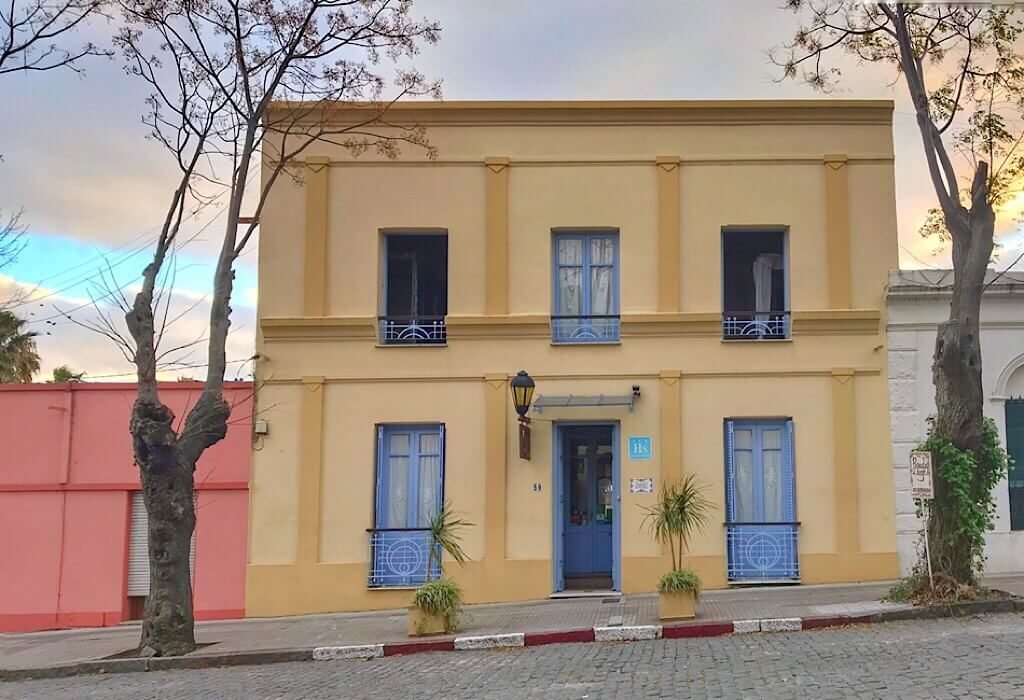 Yellow home with blue shutters and a blue door in Uruguay