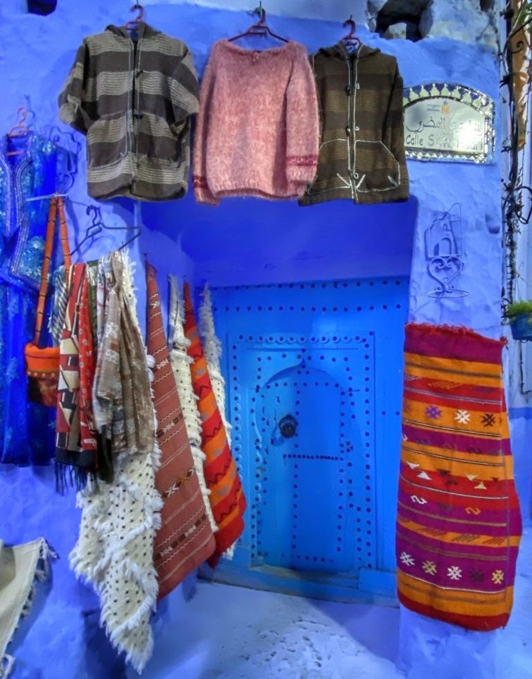 Wares for sale hanging on blue walls 