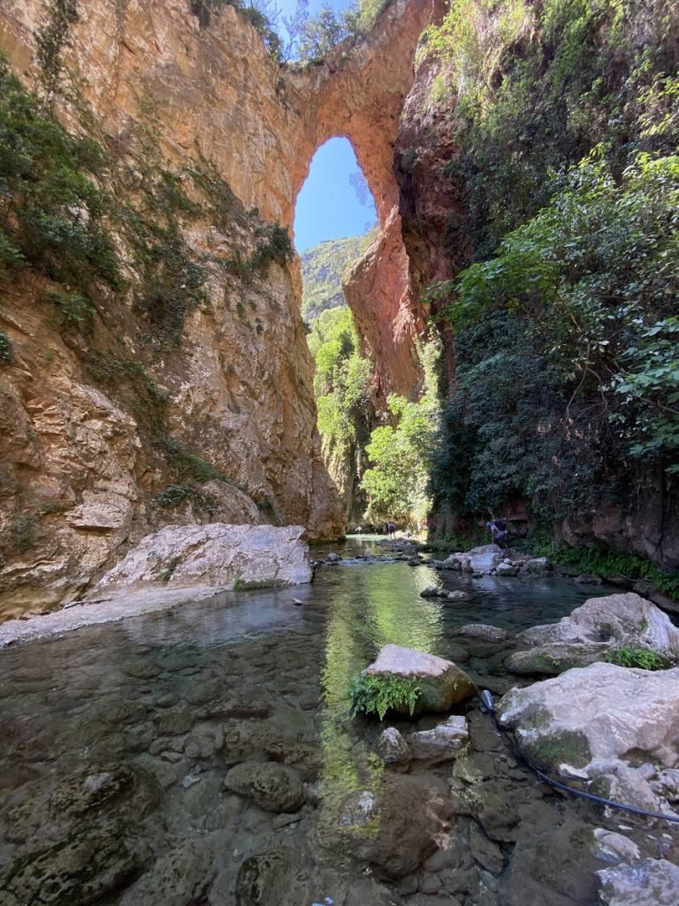 The bridge of the gods, a natural rock bridge high above the clear river water in Talassemtane National Park