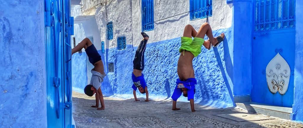 Three boys doing handstands in Chefchouen