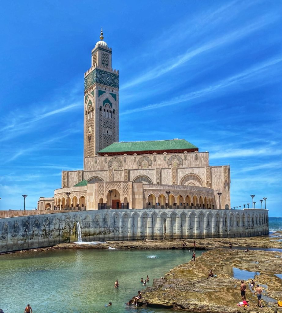 The Hassan II tower against a blue sky sitting on the coast of Casablanca