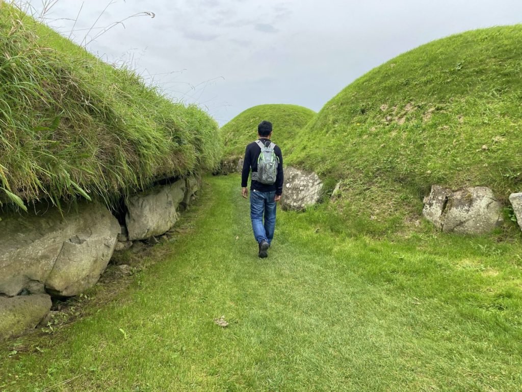 Trin walking between burial mounts at the Knowth site in Brú na Bóinne Valley