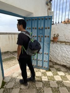 Trin standing next to an open blue door