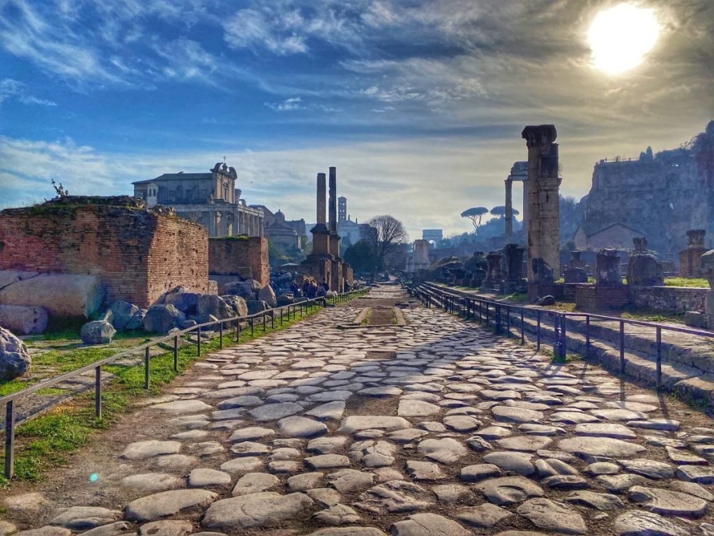 The Vicus route paved with large stones leading through the Roman Forum and surrounded by Roman ruins.