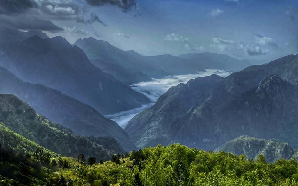 Viewpoint into the valley. the mountains appear blue-gray and fog rests in the valley.