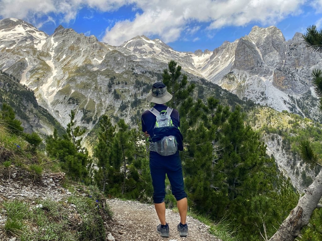 Trin on the path beyond Valbona Pass looking at snow capped mountains