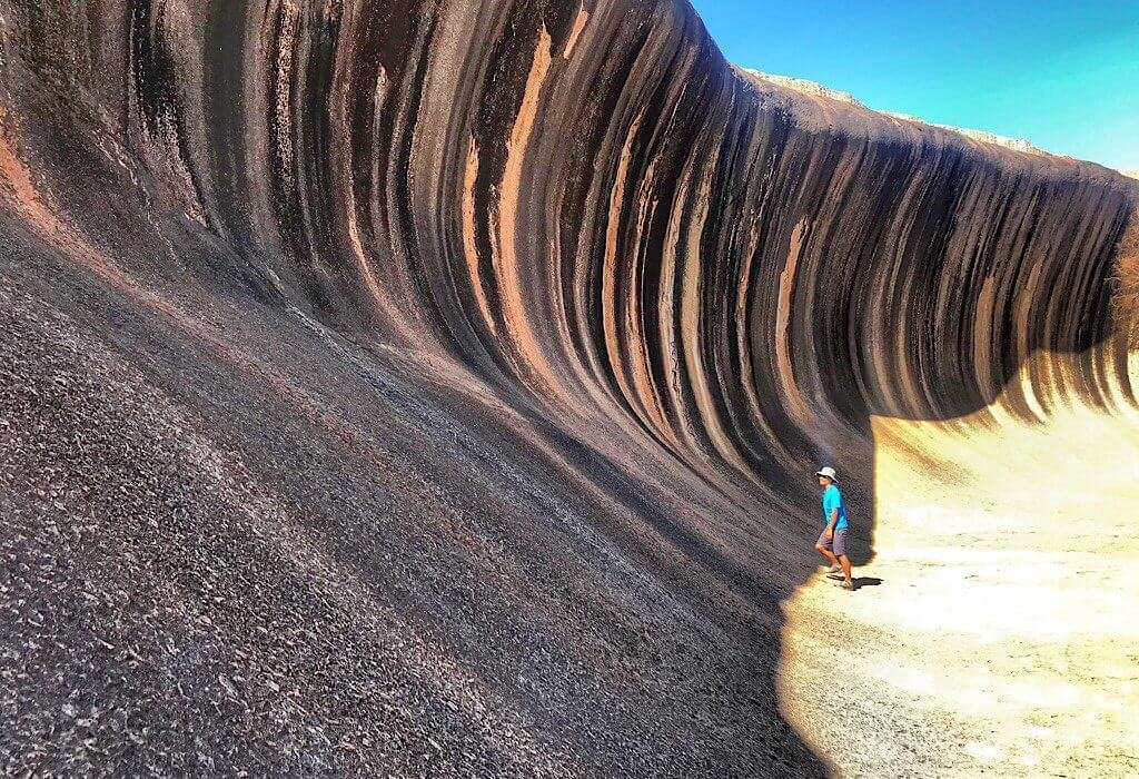 One massive smooth rock towers over Trin like a wave