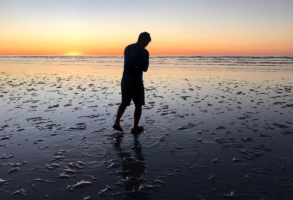 Trin standing on 80 mile beach at sunset