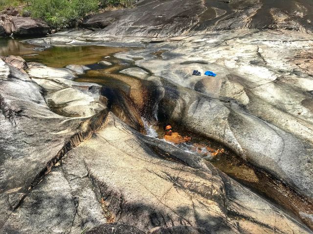 Trin sliding down the smooth rocks of Crystal Creek