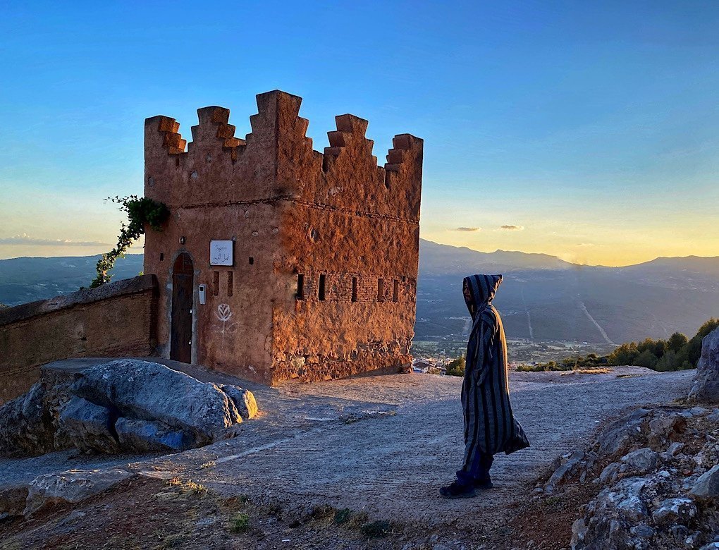 Trin standing by one of the city towers surrounding Chefchouen, Morocco