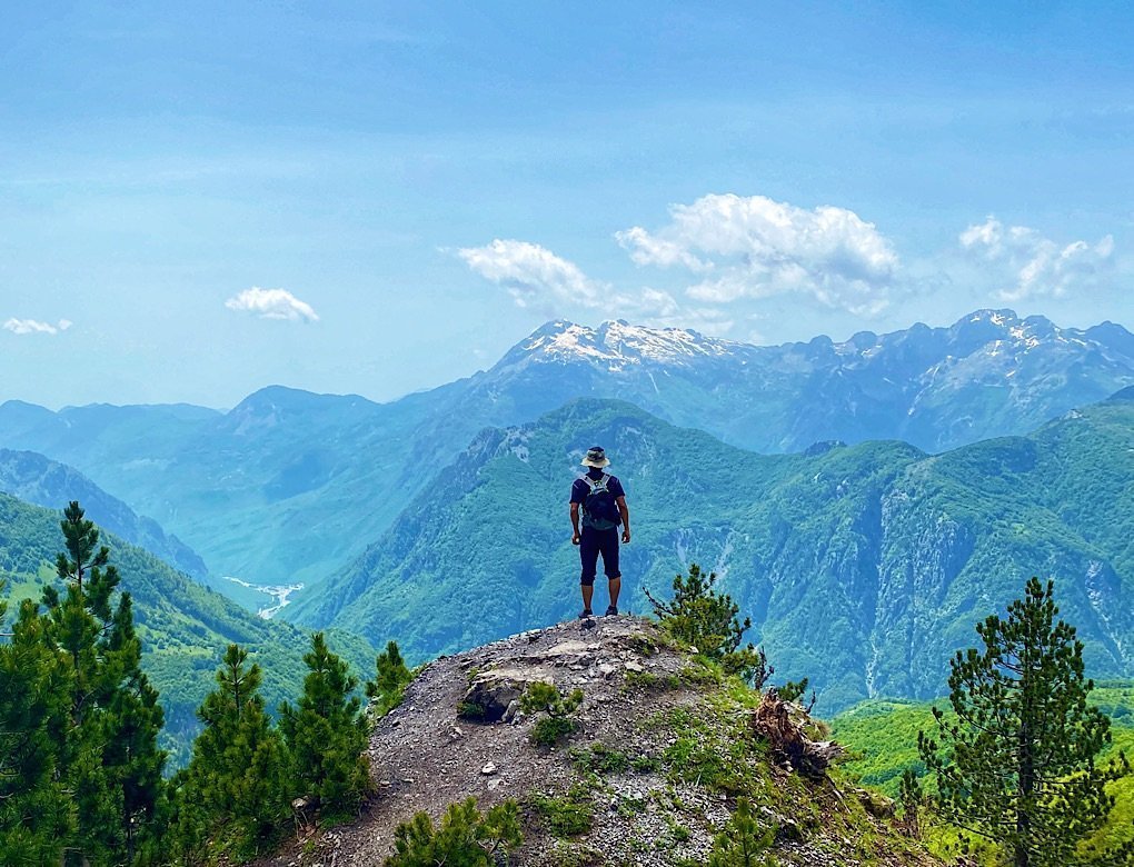 Trin standing on an outcropping looking over the valley on the way up to Valbona Pass