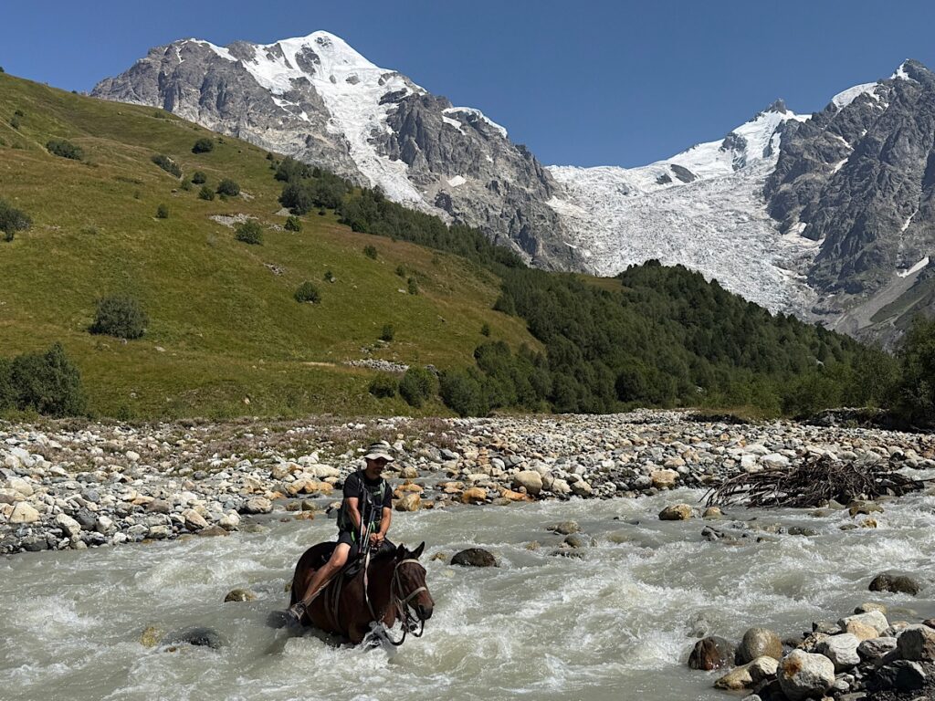 Trin crossing the glacial rive on horseback