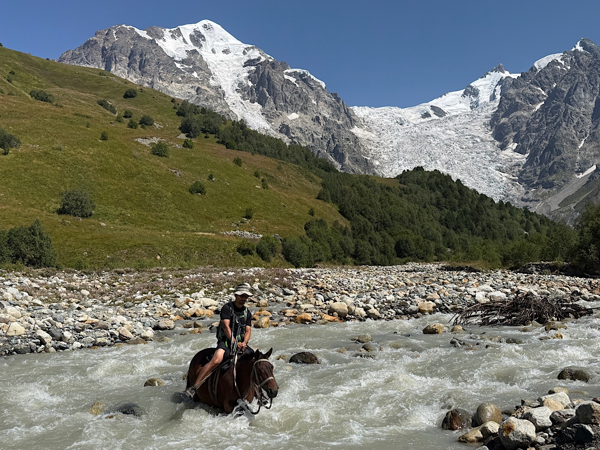 Trin crossing the glacial rive on horseback