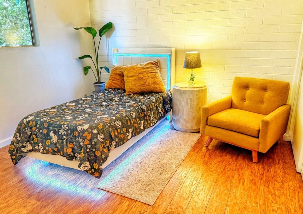 Mom's new room with a floating bed frame and chair from the set of Mad Men.