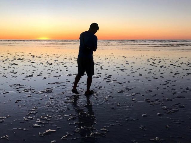 Trin standing on 80 mile beach at sunset