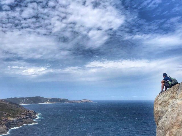 Trin sitting on the edge of Stony Hill in Torndirrup National Park
