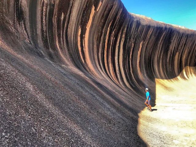 One massive smooth rock towers over Trin like a wave